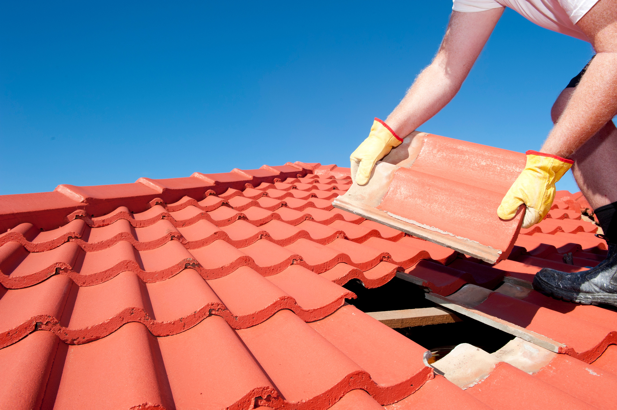 Construction worker tile roofing repair
