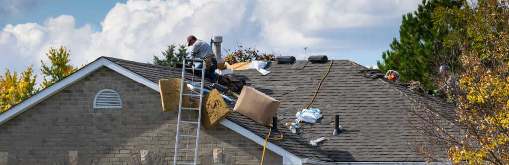 Worker on the roof of a 2-storey house for roof repair