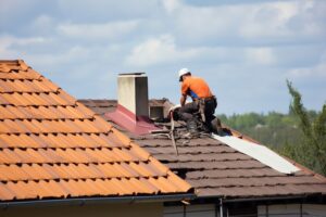 roof repair expert working on roof of a house
