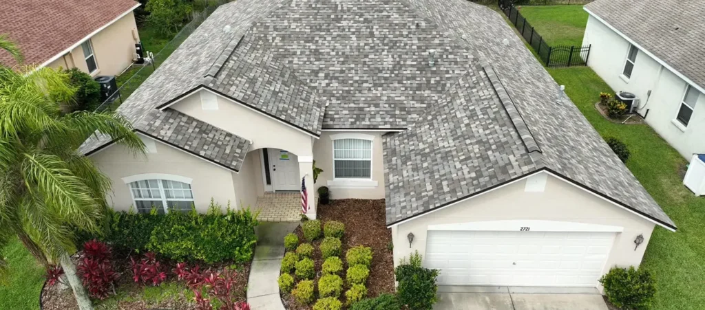 Front exterior of a two-story home with a shingle roof installation in Miramar, Florida surrounded by palm trees