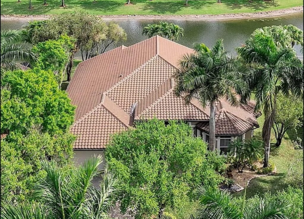 Aerial view of a waterfront home with a shingle roof replacement in Fort Lauderdale, Florida overlooking a private dock