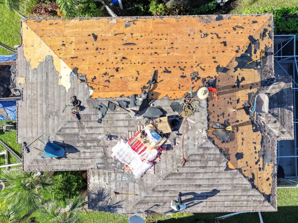 Overhead view of a storm-damaged roof being torn off in South Florida