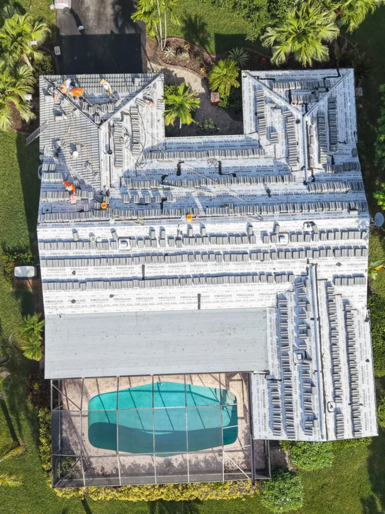 Aerial view of a Fort Lauderdale home with new roof tiles staged for installation