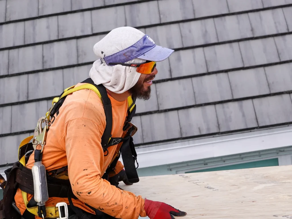 Tiger Team Roofing technician working along the roof edge of a South Florida home
