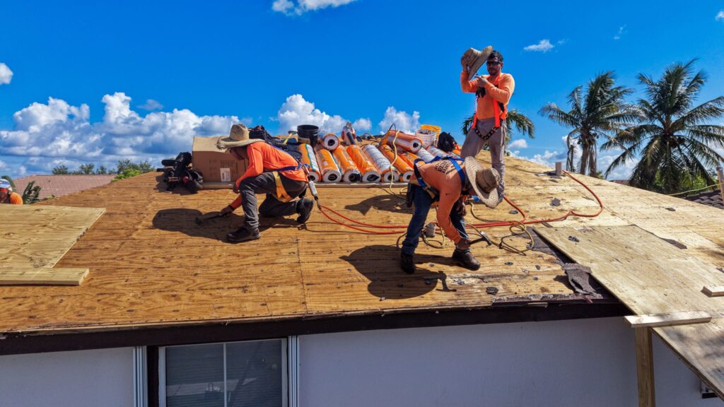 Roofing crew installing new roof decking during a residential roof replacement.
