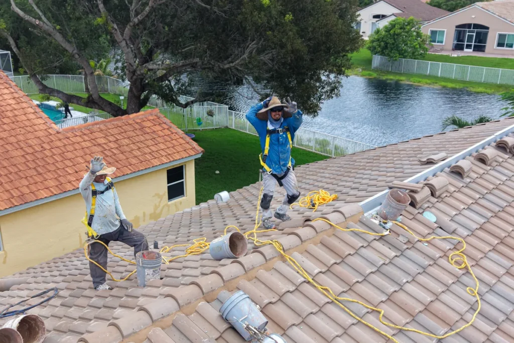 Tiger Team Roofing crew working on a tile roof at a waterfront South Florida home