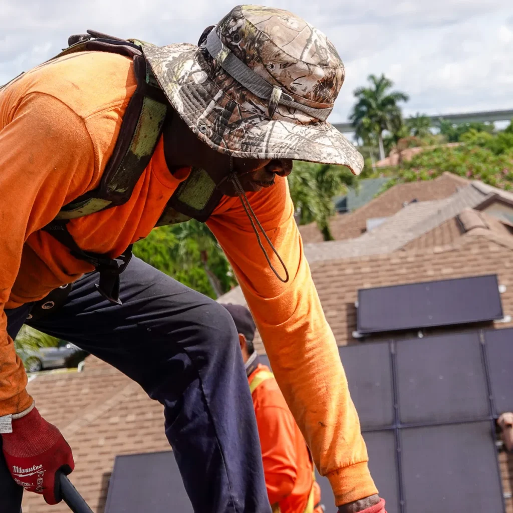 Tiger Team Roofing technician removing wind-damaged roofing debris in Fort Lauderdale